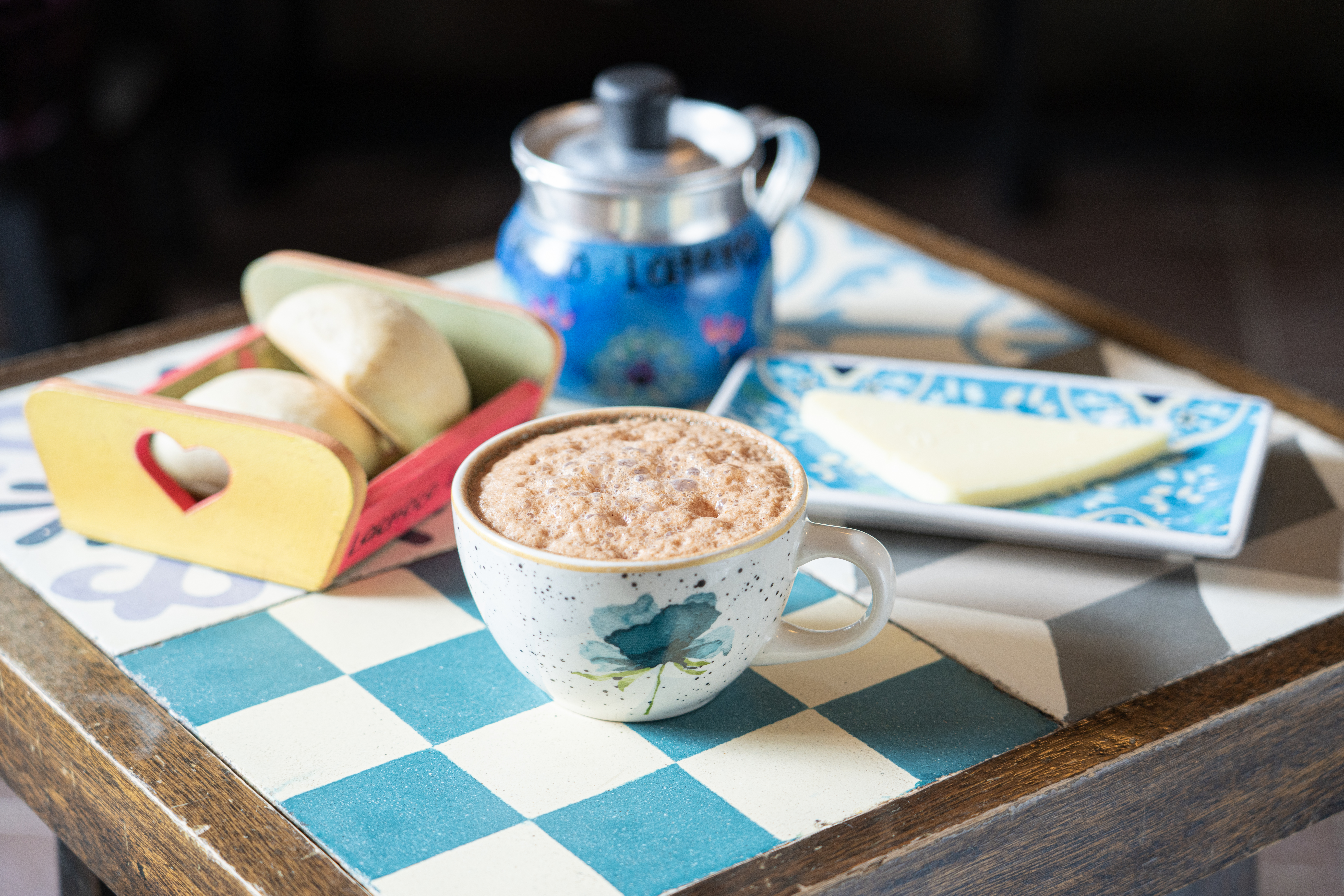 Taza de chocolate caliente con pan y queso